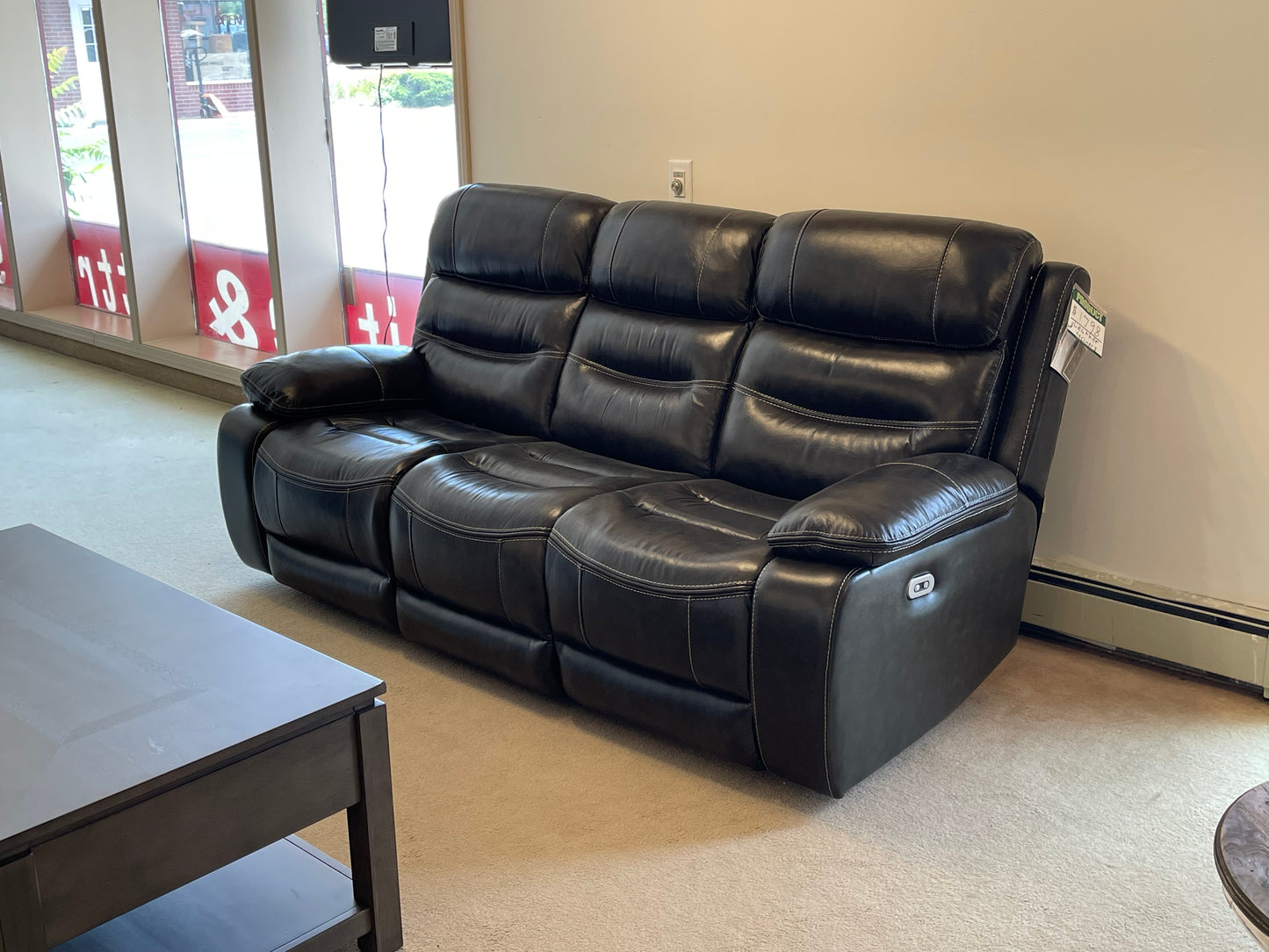 a couple of black leather couches in a room 