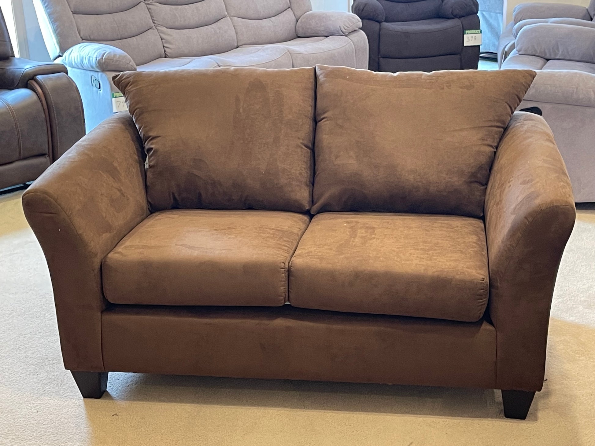 a brown couch sitting on top of a wooden floor 